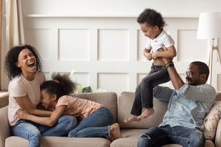 Black family laughing on couch