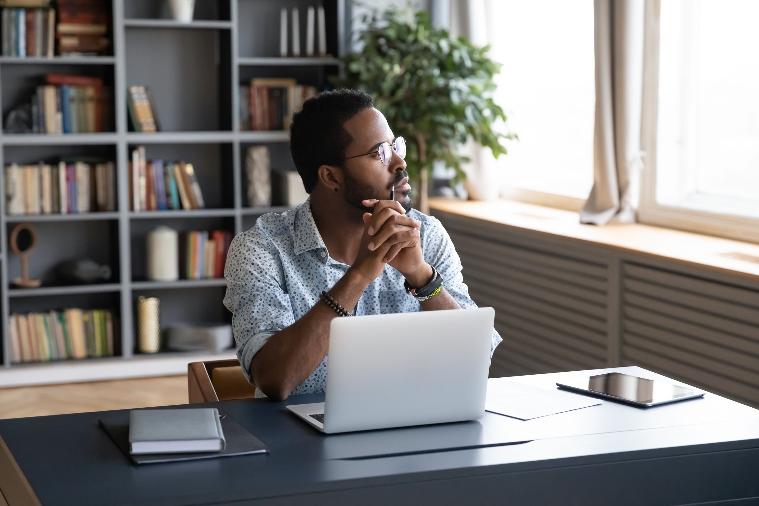 Black man thinking at desk