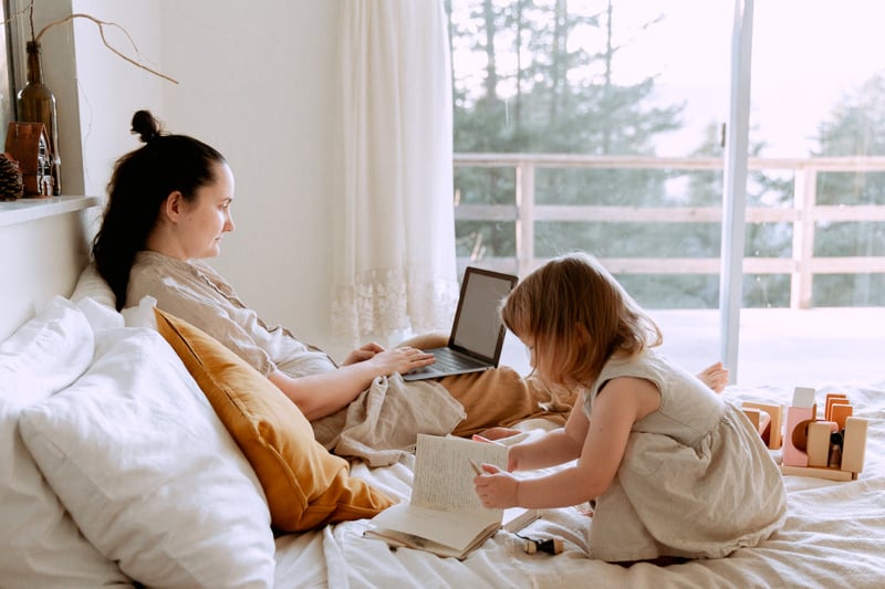 Canva - Mother working remotely while daughter drawing nearby