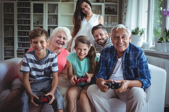 Family watching the kids playing video game at home